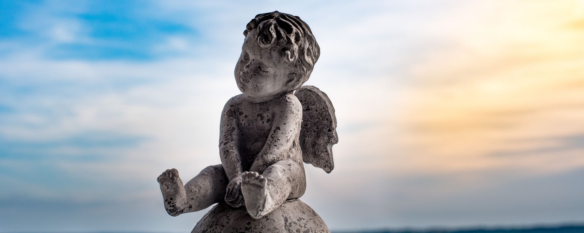 Statue of an angel against a blue sky backdrop